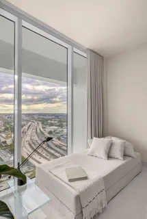 a spacious bedroom with a large window and a bed