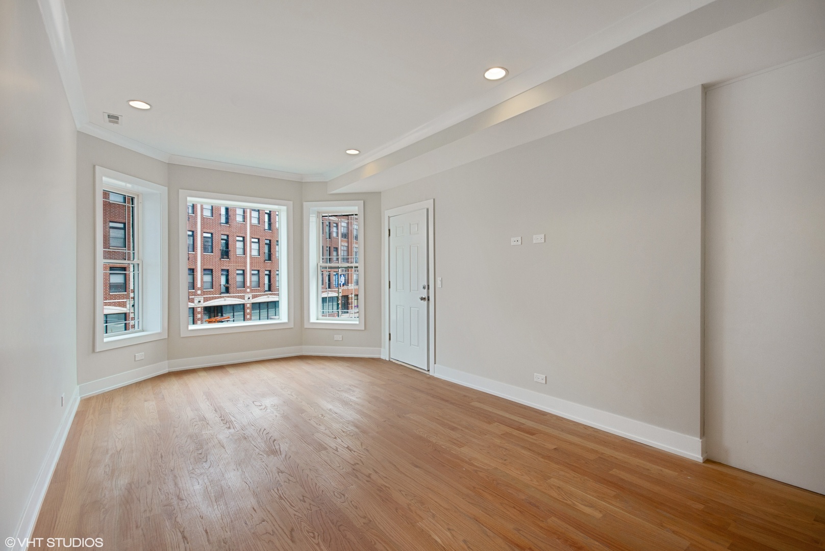3750 North Racine Avenue, Unit 2 Chicago, IL 60613 - Photo 2 of 10 a view of an empty room with a window and wooden floor