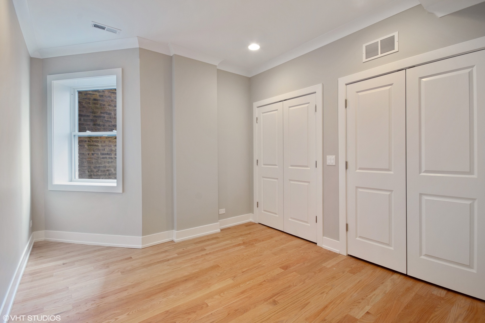 3750 North Racine Avenue, Unit 2 Chicago, IL 60613 - Photo 5 of 10 a view of an empty room with wooden floor and a window