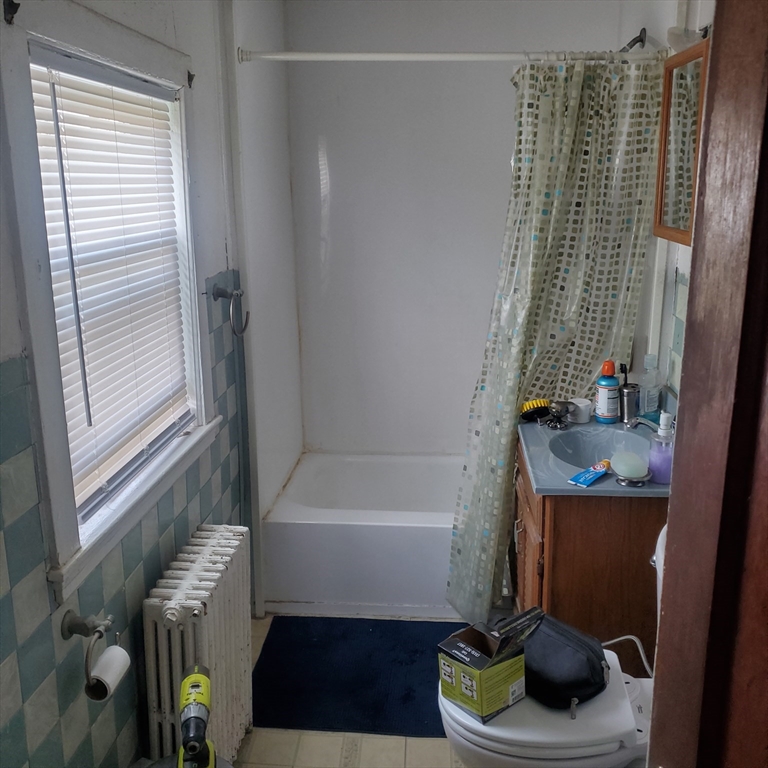 27 Halborn Street Boston, MA 02126 - Photo 5 of 20 a bathroom with a bathtub a sink and a window