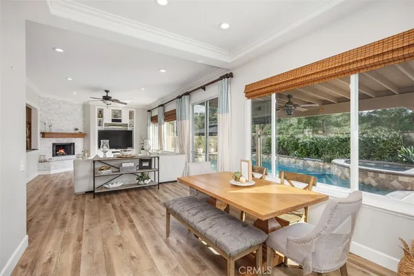 a living room with a table and kitchen view with wooden floor