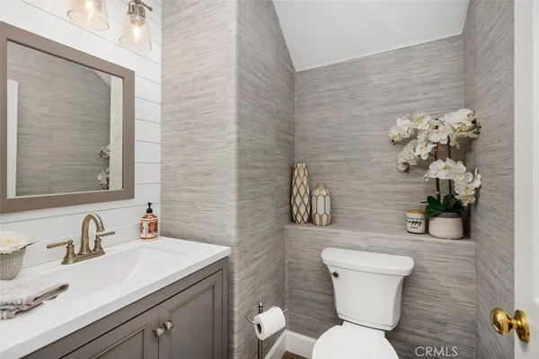 a bathroom with a granite countertop toilet sink and mirror