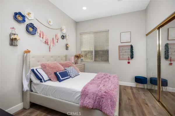 a bedroom with a bed and a table with wooden floor