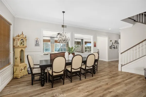 a dining room with furniture a chandelier and wooden floor