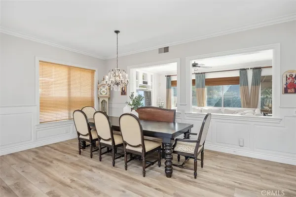 a dining room with furniture a chandelier and wooden floor