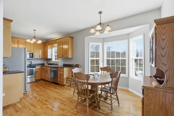 a view of a dining room with furniture a chandelier and wooden floor