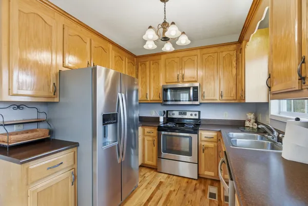 a kitchen with stainless steel appliances granite countertop a sink a stove a microwave oven and cabinets