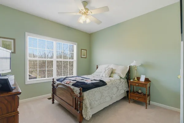 a bed sitting in a bedroom next to a window