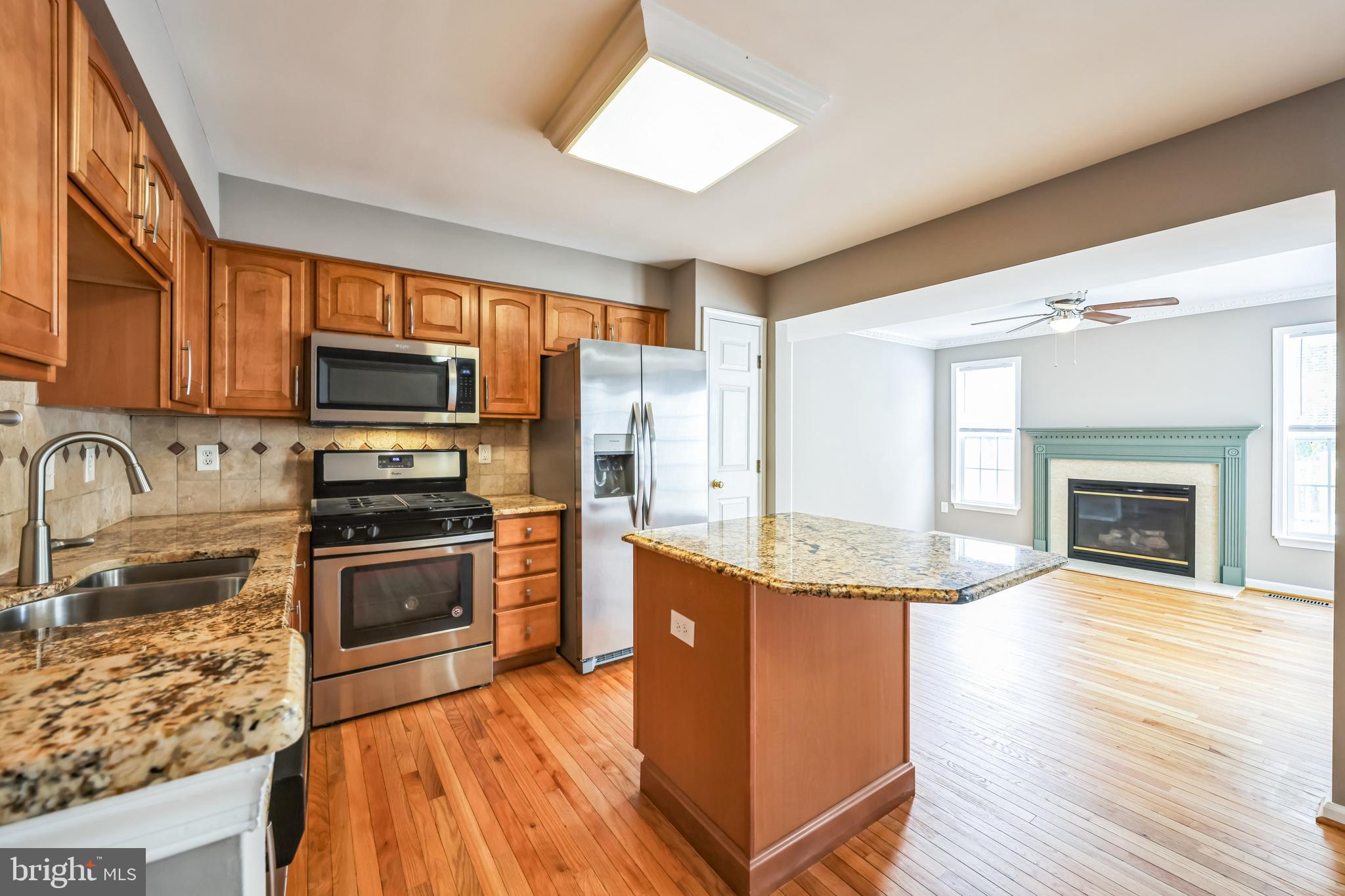 76 Millstream Road Pine Hill, NJ 08021 - Photo 15 of 30 a kitchen with stainless steel appliances granite countertop a stove top oven a sink dishwasher a refrigerator and a fireplace with wooden floor