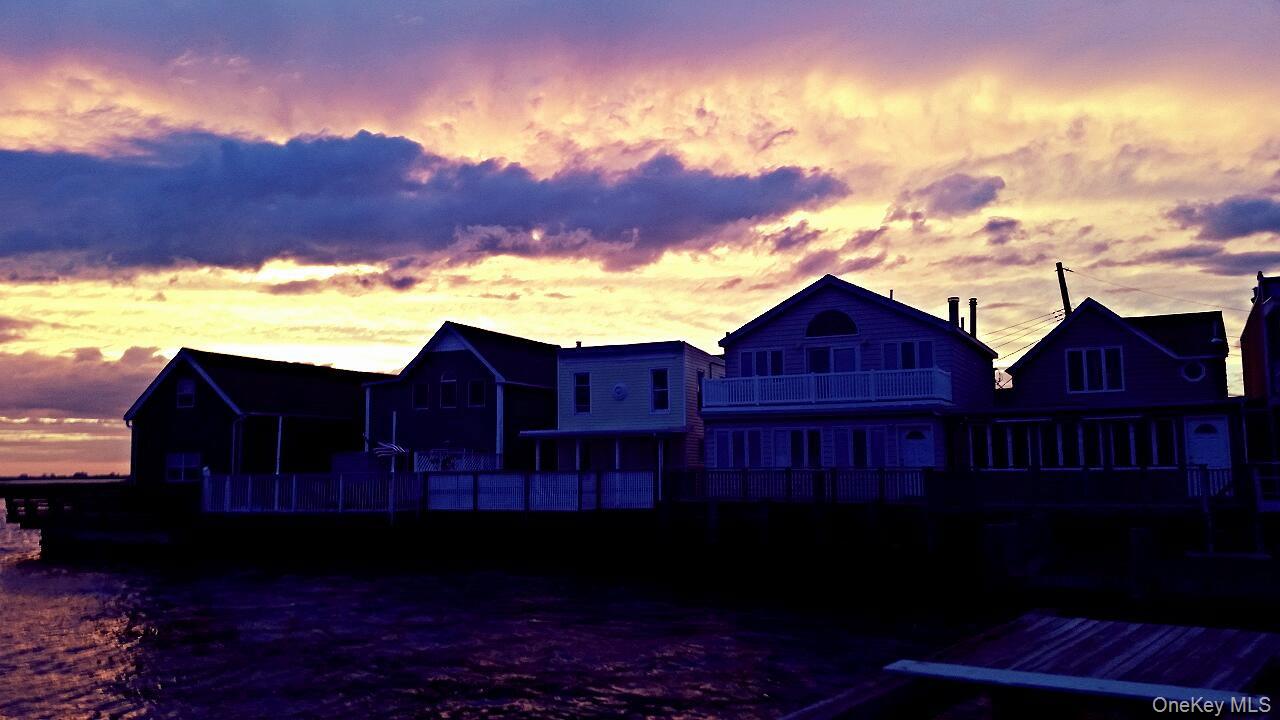 12-14 West 5th Road Queens, NY 11693 - Photo 41 of 43 Back of house at dusk with a deck