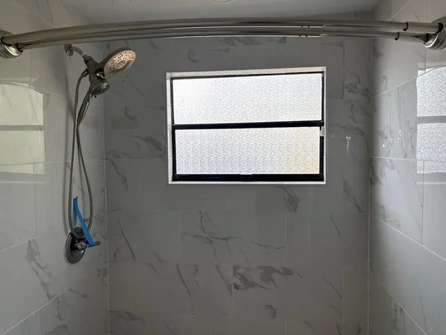 a bathroom with a shower and a window