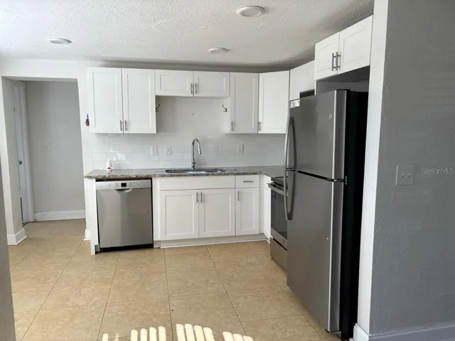 a kitchen with a stove a sink and a refrigerator