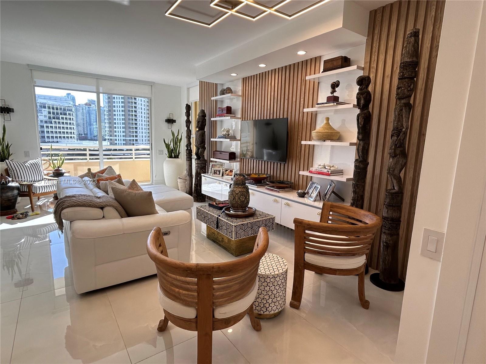 888 Brickell Key Drive, Unit 802 Miami, FL 33131 - Photo 20 of 42 a living room with furniture a flat screen tv and a window