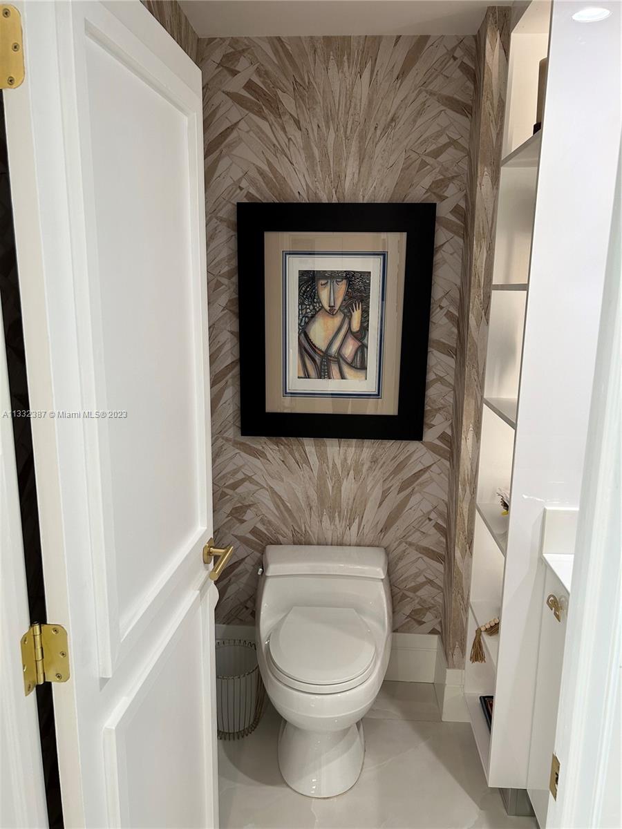 888 Brickell Key Drive, Unit 802 Miami, FL 33131 - Photo 28 of 42 a bathroom with a toilet and a painting on the wall