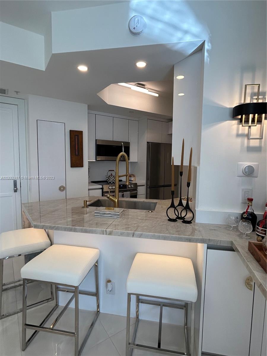 888 Brickell Key Drive, Unit 802 Miami, FL 33131 - Photo 31 of 42 a room with table chairs and a dining table