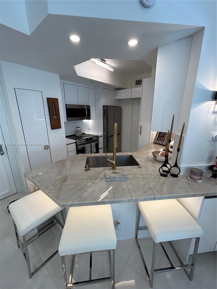 888 Brickell Key Drive, Unit 802 Miami, FL 33131 - Photo 38 of 42 a living room with furniture and a flat screen tv