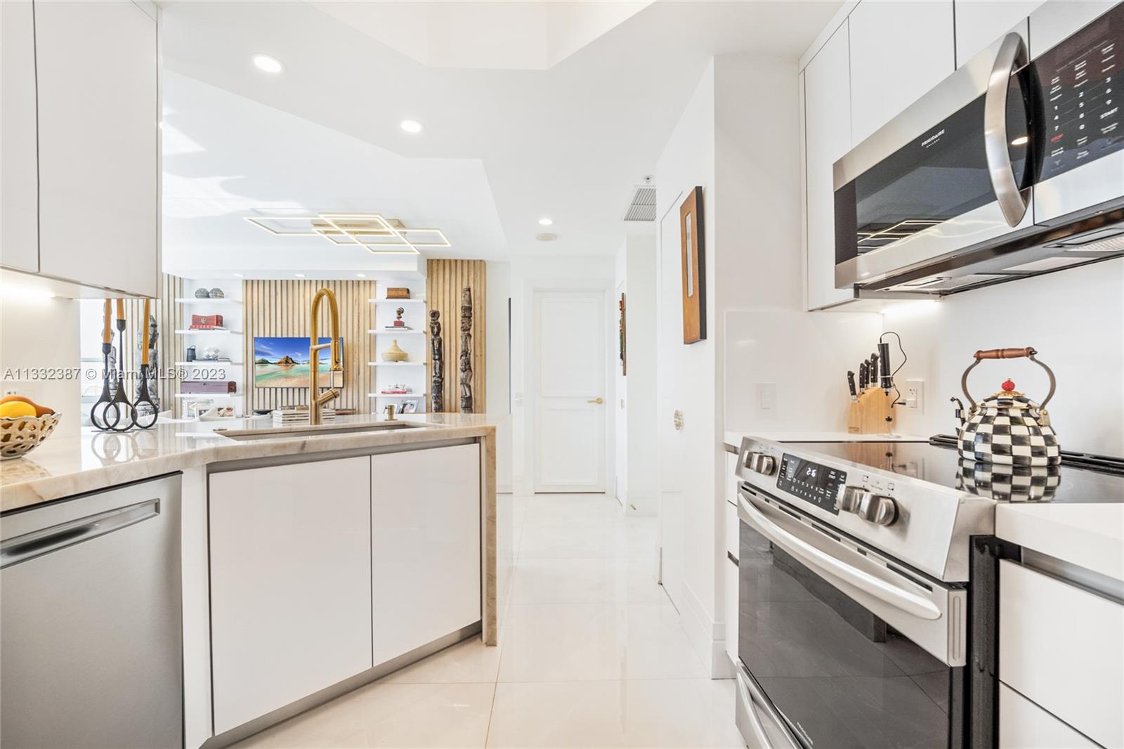 888 Brickell Key Drive, Unit 802 Miami, FL 33131 - Photo 5 of 42 a kitchen with stainless steel appliances granite countertop a stove a sink and a microwave