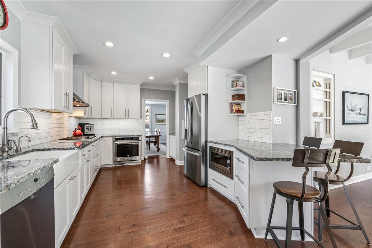 909 Locust Road Wilmette, IL 60091 - Photo 15 of 45 a large kitchen with stainless steel appliances lots of counter space and wooden floors