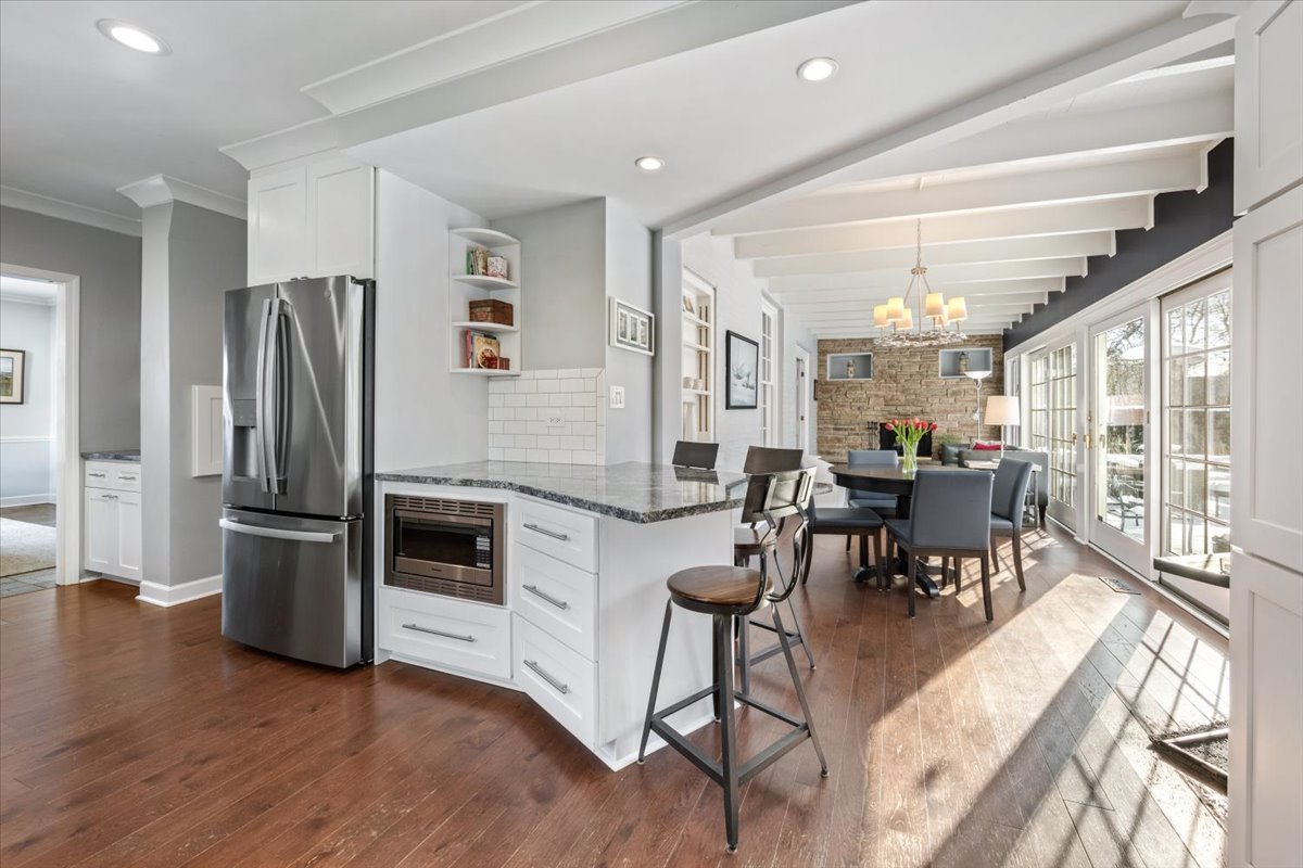 909 Locust Road Wilmette, IL 60091 - Photo 18 of 45 a kitchen with stainless steel appliances kitchen island granite countertop a refrigerator a stove a dining table and chairs with wooden floor