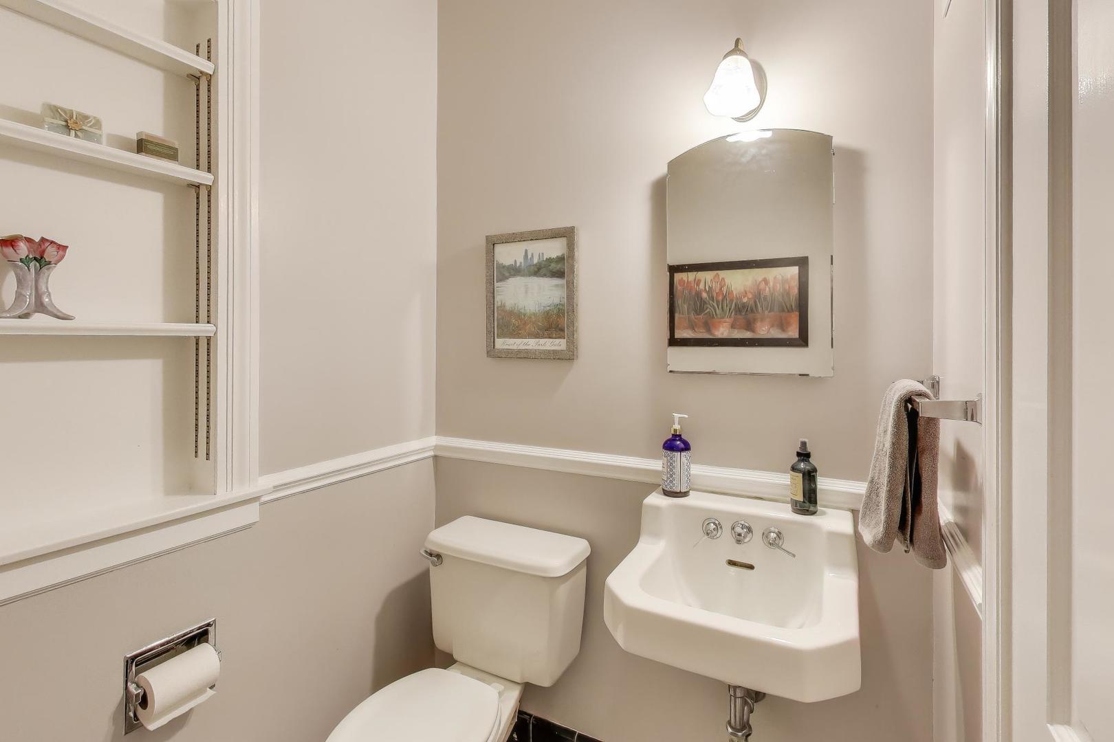 909 Locust Road Wilmette, IL 60091 - Photo 19 of 45 a bathroom with a toilet a sink and mirror