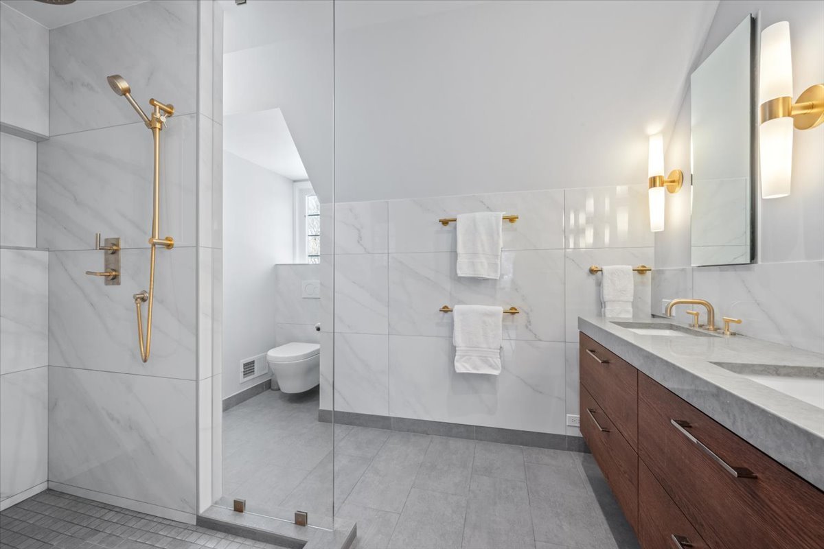 909 Locust Road Wilmette, IL 60091 - Photo 23 of 45 a spacious bathroom with a granite countertop sink a toilet and a shower
