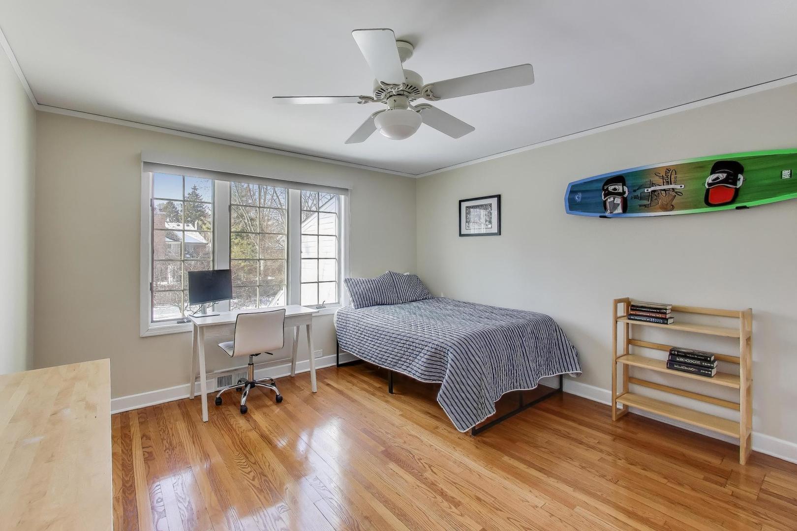 909 Locust Road Wilmette, IL 60091 - Photo 29 of 45 a bedroom with a bed and a desk with wooden floor