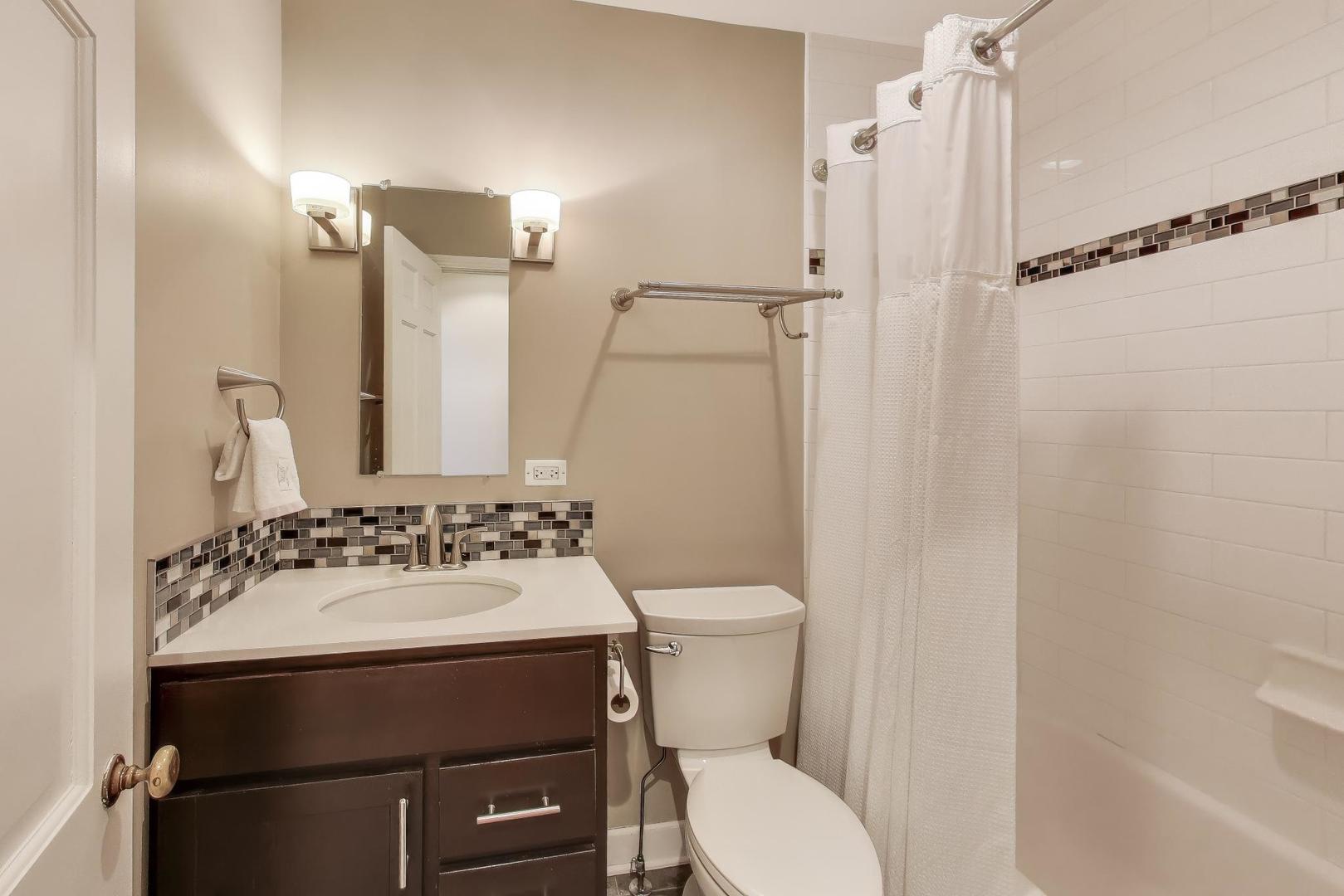 909 Locust Road Wilmette, IL 60091 - Photo 32 of 45 a bathroom with a sink mirror toilet and shower