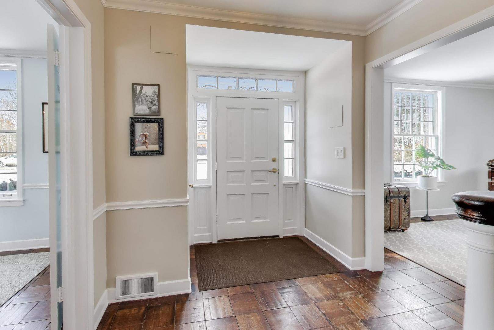 909 Locust Road Wilmette, IL 60091 - Photo 4 of 45 a view of a hallway with wooden floor and a living room