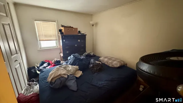 a bed sitting in a bedroom next to a window