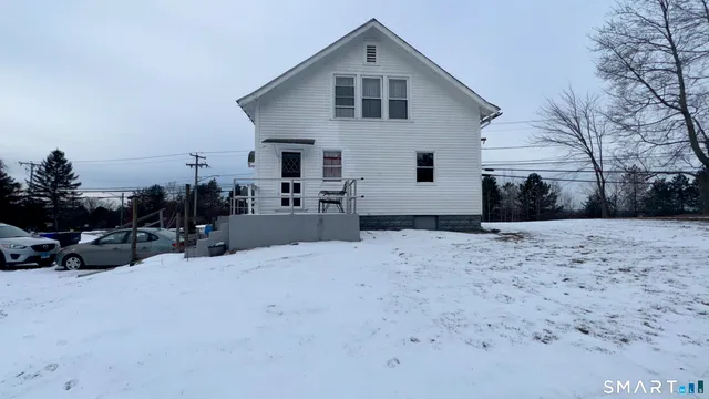 a view of a house with a yard covered in snow