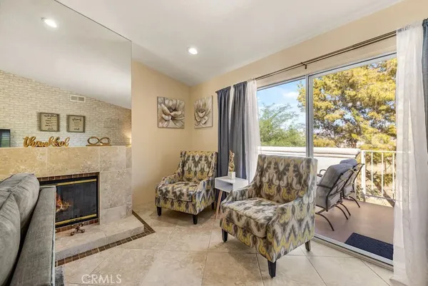 a living room with furniture large window and a fireplace