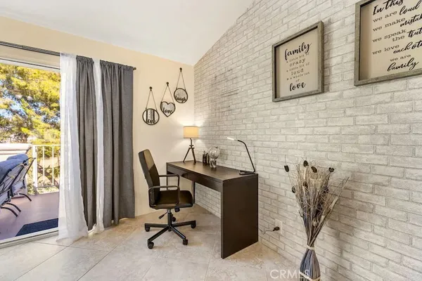 a view of a workspace with furniture and a window
