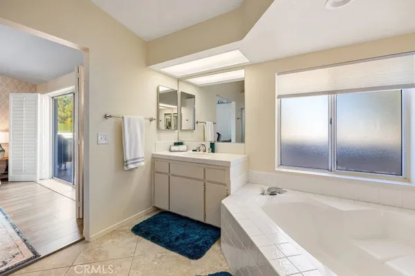 a bathroom with a tub sink shower and mirror