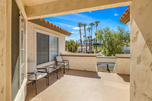 a balcony with furniture and a potted plant