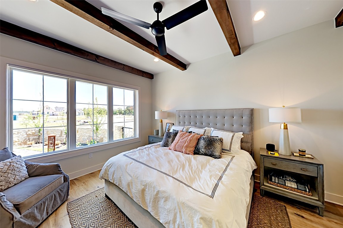 19517 Flying J Boulevard, Unit 6 Spicewood, TX 78669 - Photo 12 of 32 a bedroom with a bed a couch and a window