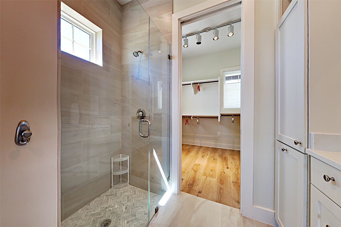 19517 Flying J Boulevard, Unit 6 Spicewood, TX 78669 - Photo 15 of 32 a bathroom with a granite countertop shower and a mirror