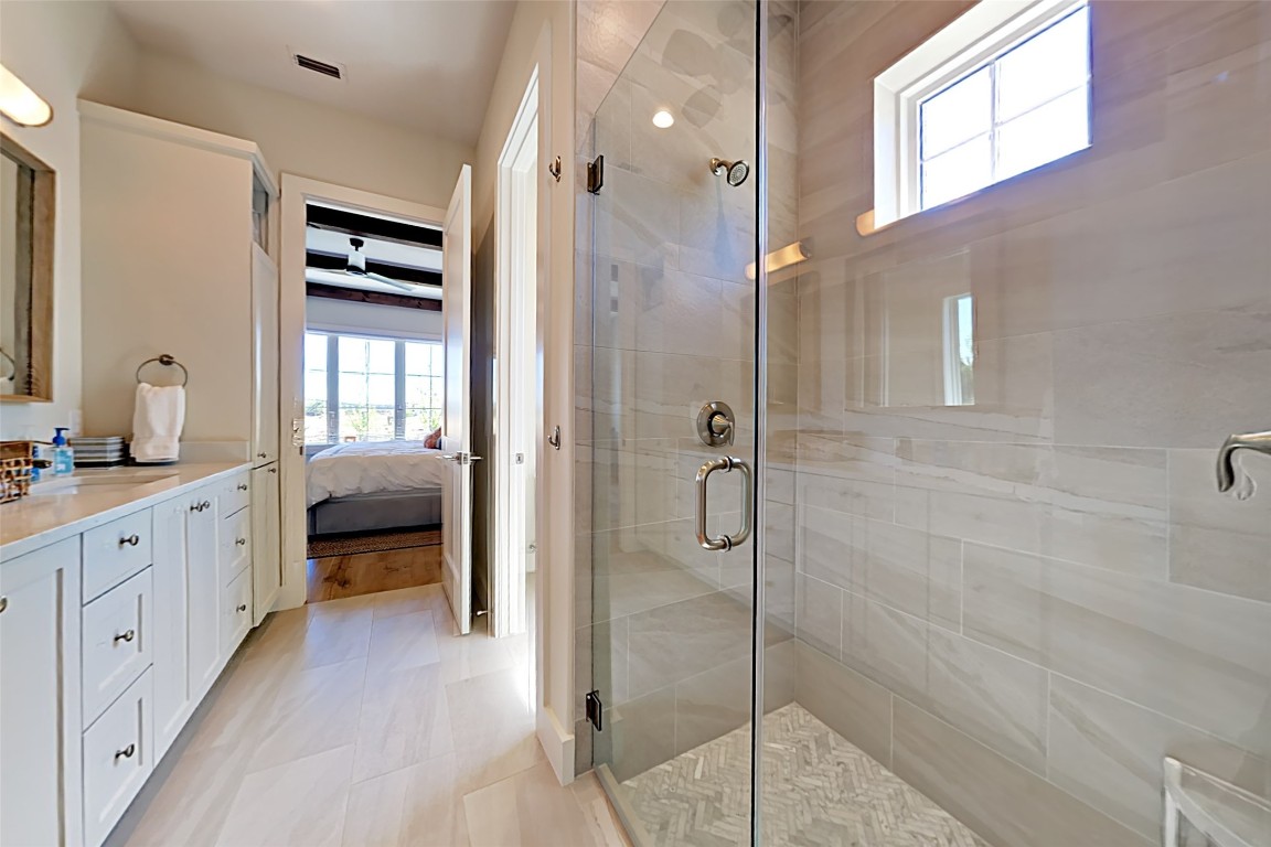 19517 Flying J Boulevard, Unit 6 Spicewood, TX 78669 - Photo 20 of 32 a en suite spacious bathroom with a shower and a sink