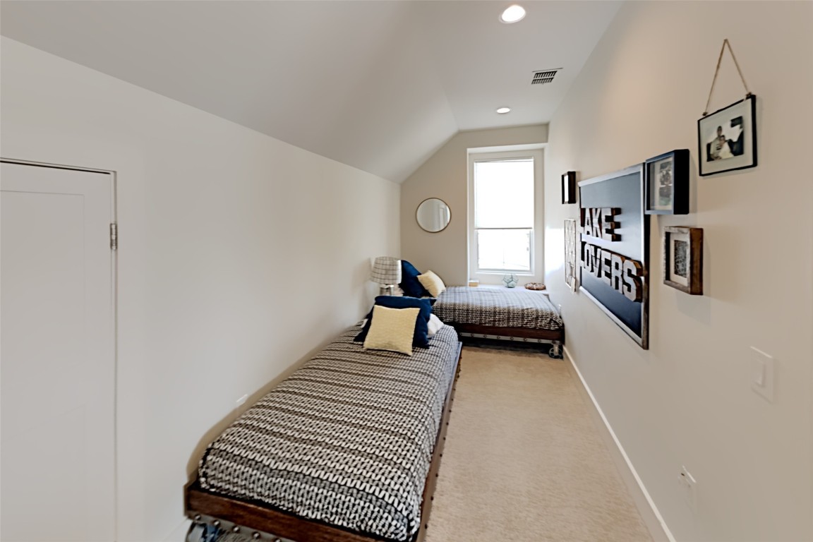 19517 Flying J Boulevard, Unit 6 Spicewood, TX 78669 - Photo 22 of 32 a bedroom with a bed and a chandelier