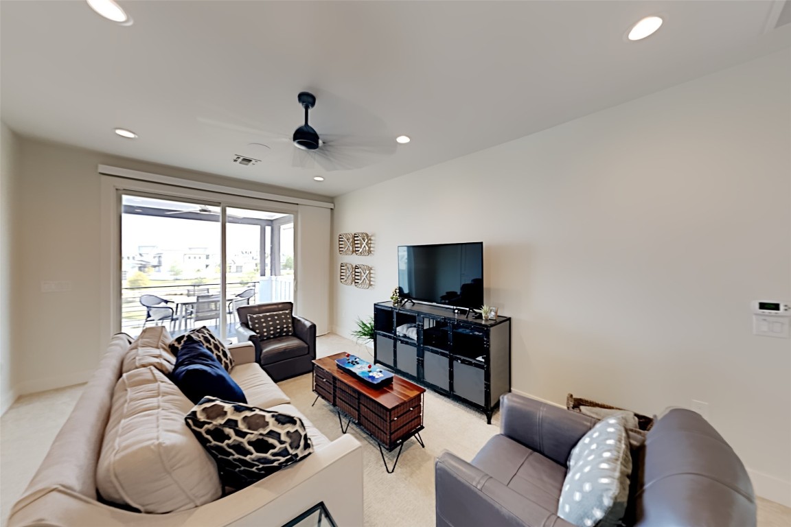 19517 Flying J Boulevard, Unit 6 Spicewood, TX 78669 - Photo 25 of 32 a living room with furniture and a flat screen tv
