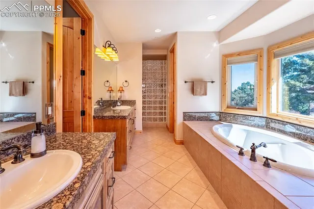 a large spacious bathroom with a tub a double vanity sink and mirror