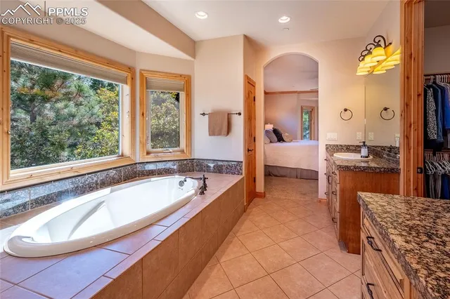 a spacious bathroom with a granite countertop tub and a large mirror