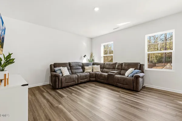 a living room with furniture wooden floor and a large window