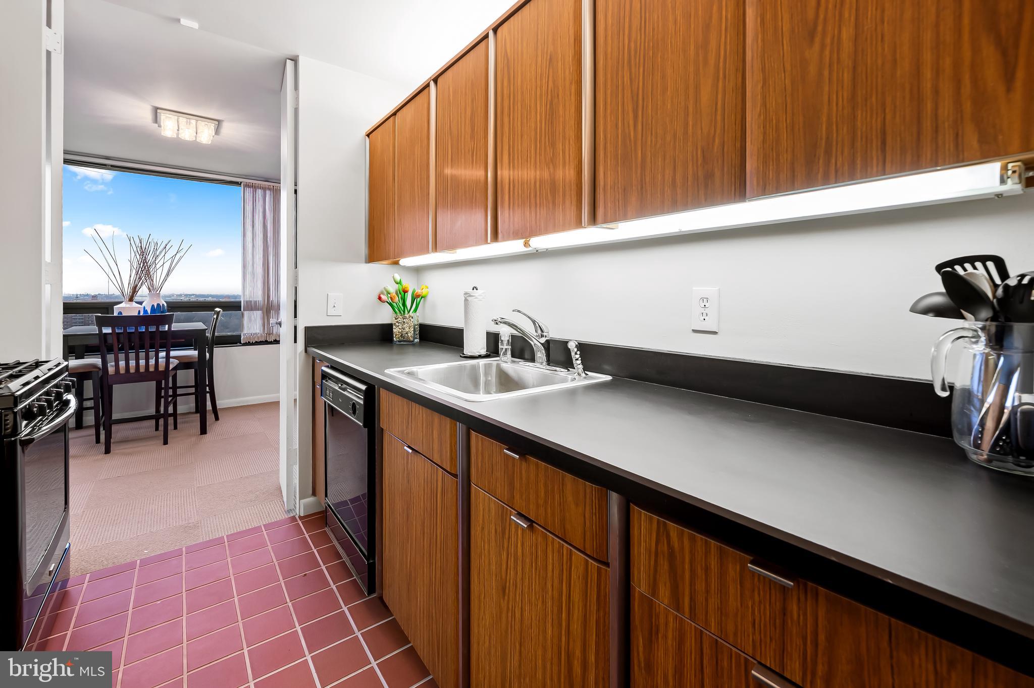 4000 North Charles Street, Unit 1605 Baltimore, MD 21218 - Photo 18 of 45 a kitchen with stainless steel appliances a sink dishwasher and cabinets with wooden floor