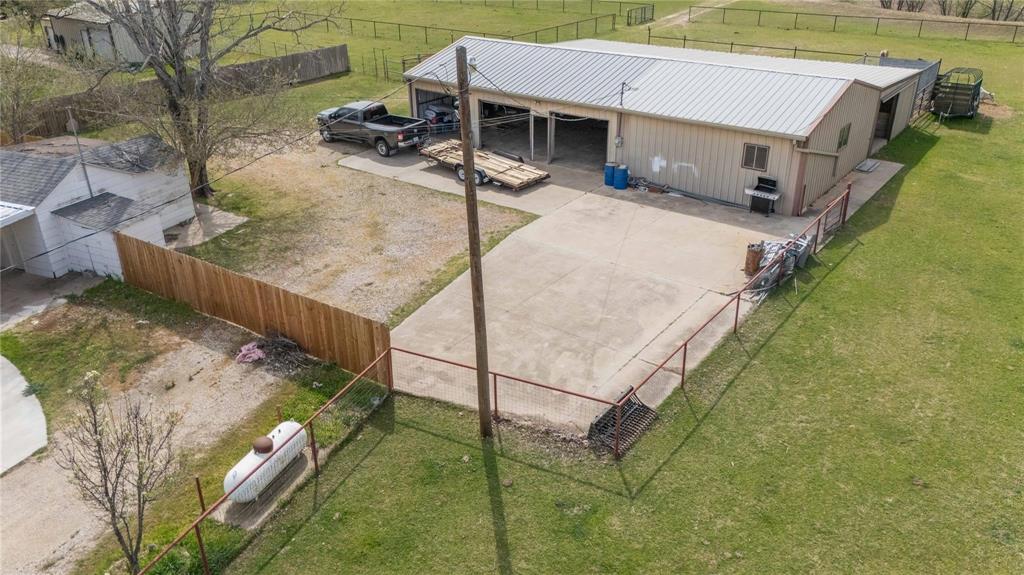 900 Silver Creek Azle Road Azle, TX 76020 - Photo 21 of 27 Detached metal building with a corrugated metal roof and multiple garage bays, featuring a spacious concrete pad