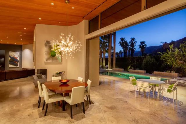 a view of a patio with dining table and chairs with plants and garden view