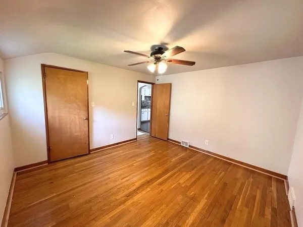 a view of an empty room and a ceiling fan