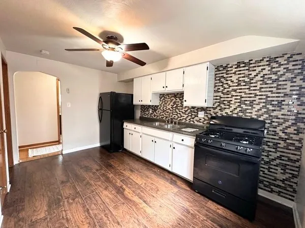 a kitchen with granite countertop cabinets and black appliances