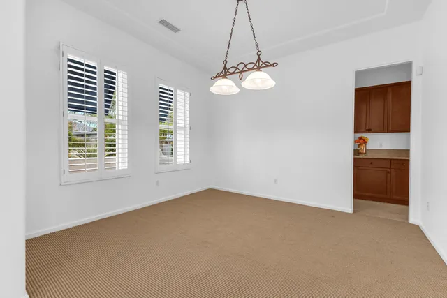 a view of empty room with a kitchen