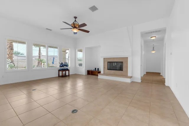 a view of an empty room with a fireplace and a window