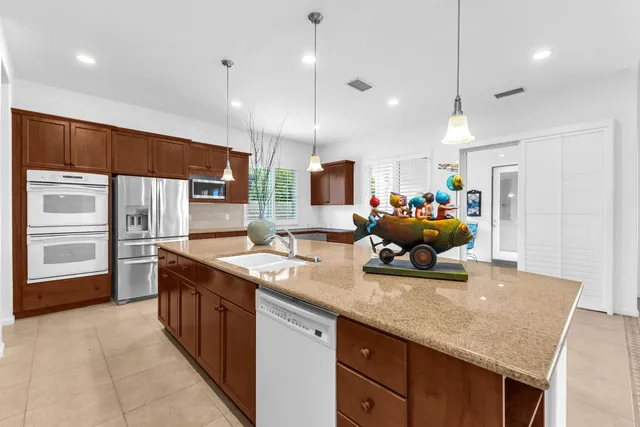 a kitchen with stainless steel appliances granite countertop a sink refrigerator and cabinets
